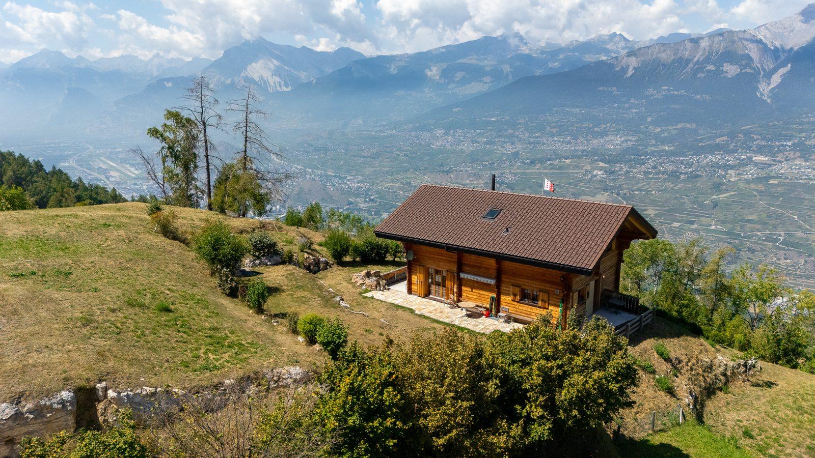 Luftaufnahme eines Chalets über einem Schweizer Tal